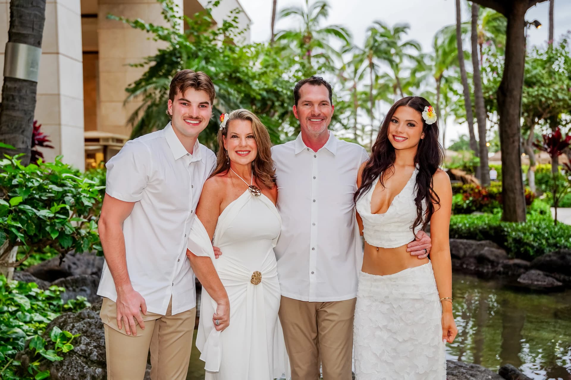 Family of four in white outfits at tropical resort